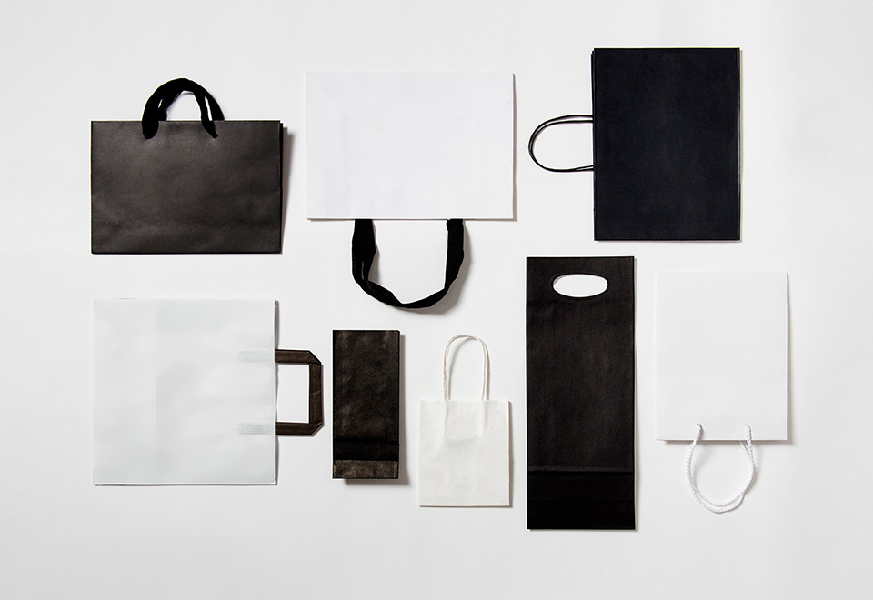Flat lay of black and white paper carry bags. 