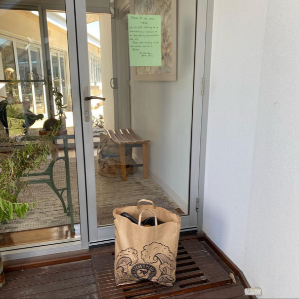 Image of paper carry bag sitting on a porch near the front door