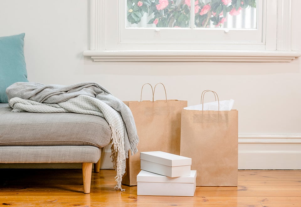 Paper carry bags and wrapped gifts placed next to lounge. 