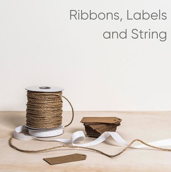 Image of jute string and white ribbon on timber desk