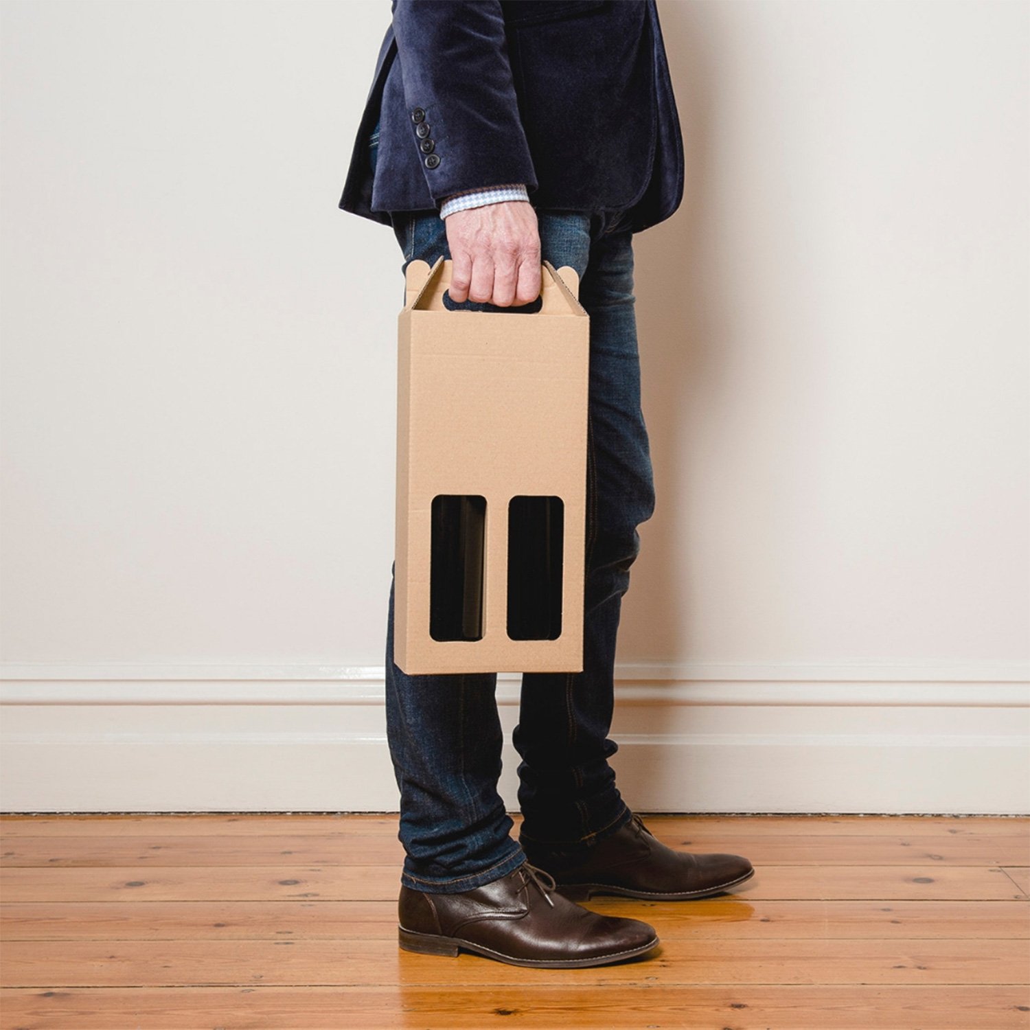 Image of a man holding wine bottles in a recyclable box